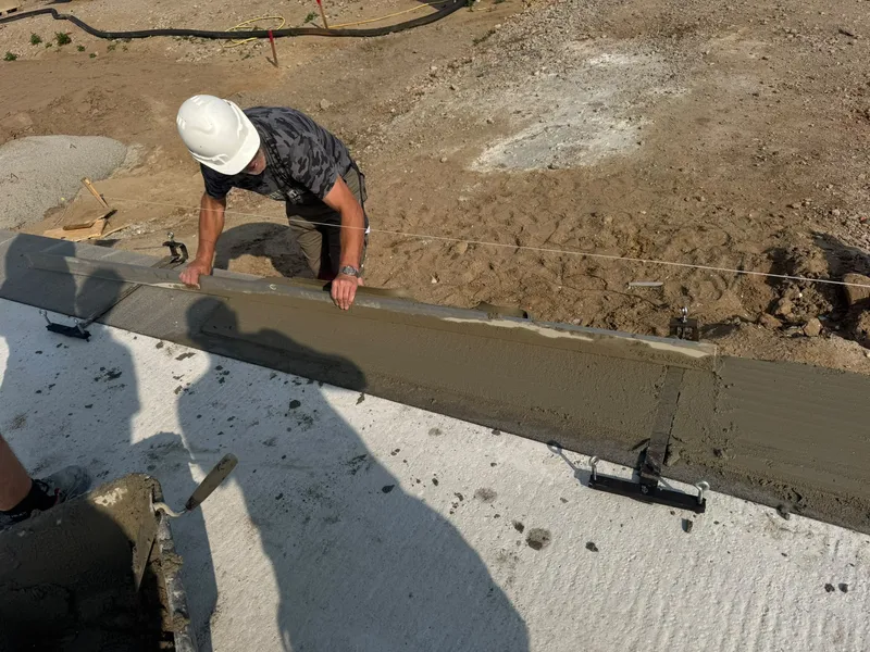 Handwerker beim sorgfältigen Abziehen einer frischen Betonfläche