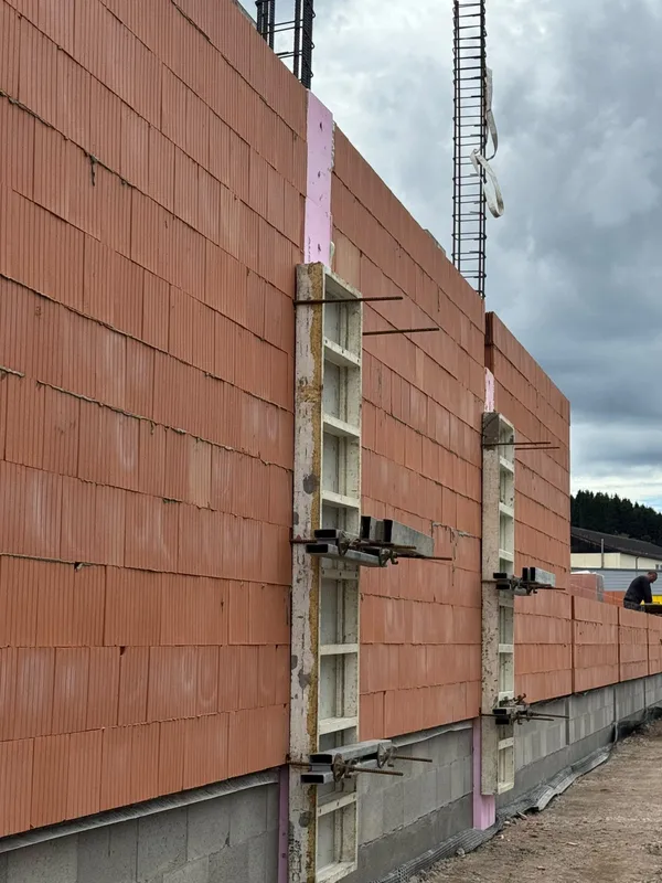 Ziegelwand mit seitlichen Schalungselementen und aufstehender Bewehrung