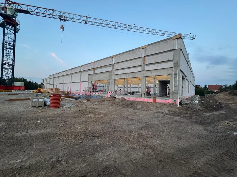 Halle mit Betonstützen, hellen Wänden und offenen Torbereichen